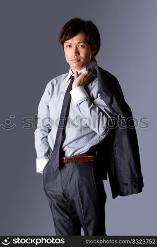 Successful Asian business man standing with confidence and jacket over his shoulder and hand in pocket, isolated.