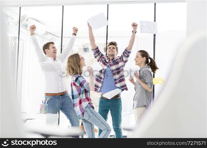 Successful business colleagues cheering in office