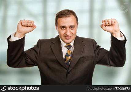 successful business man winning with arms wide open at the office