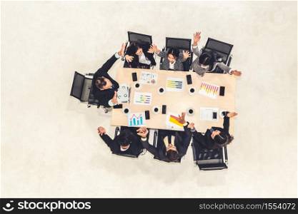 Successful business people celebrate together with joy at office table shot from top view . Young businessman and businesswoman workers express cheerful victory showing success by teamwork .