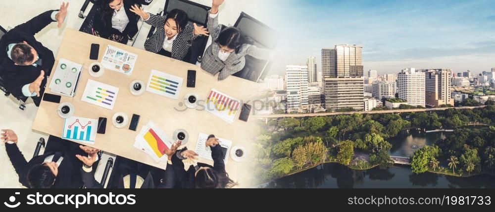 Successful business people celebrate together with joy at office table shot from top view . Young businessman and businesswoman workers express cheerful victory showing teamwork in broaden view .. Successful business people celebrate together with joy broaden view