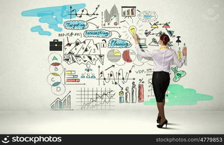 Successful business strategy plan. Businesswoman standing with back drawing business ideas on wall