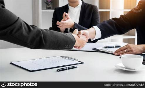 successful business team shaking hands with eachother in the office, job interview concept.