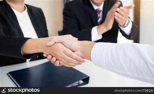 successful business team shaking hands with eachother in the office, job interview concept.