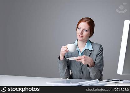 Successful business woman having coffee break at office