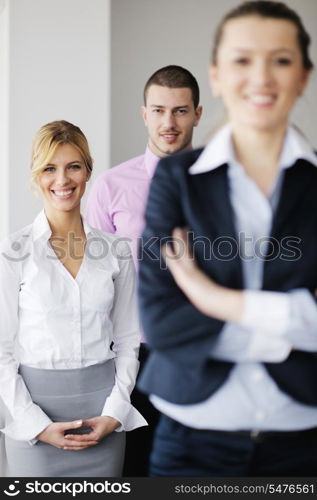 Successful business woman standing with her staff in background at modern bright office