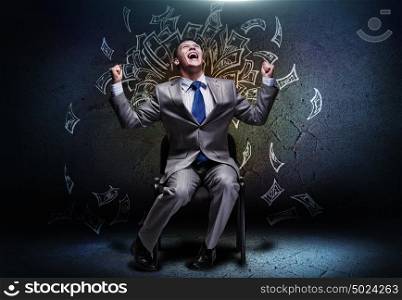 Successful businessman. Cheerful businessman sitting on chair and screaming ahead