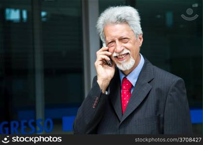successful businessman is speaking on his smartphone