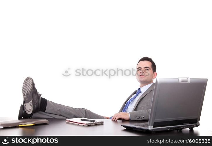Successful businessman relaxing over desk, isolated in white background