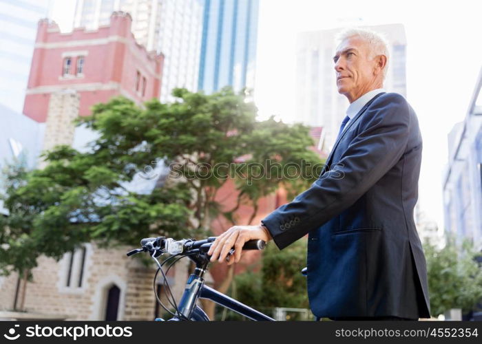 Successful businessman riding bicycle. Successful businessman in suit riding bicycle