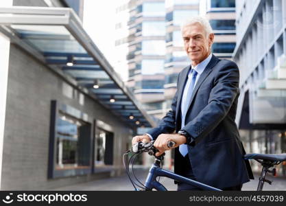 Successful businessman riding bicycle. Successful businessman in suit riding bicycle