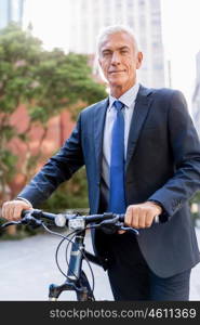 Successful businessman riding bicycle. Successful businessman in suit riding bicycle