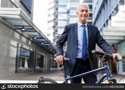 Successful businessman riding bicycle. Successful businessman in suit riding bicycle