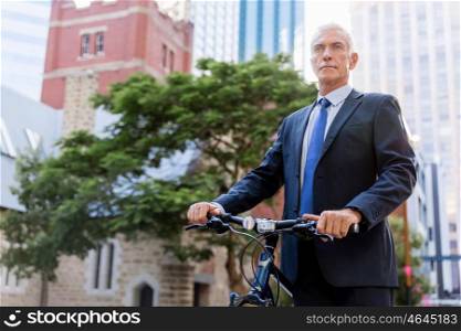 Successful businessman riding bicycle. Successful businessman in suit riding bicycle