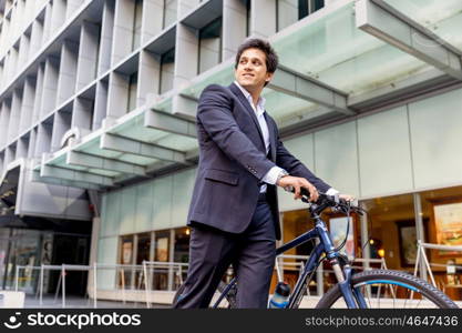 Successful businessman riding bicycle. Successful businessman in suit riding bicycle