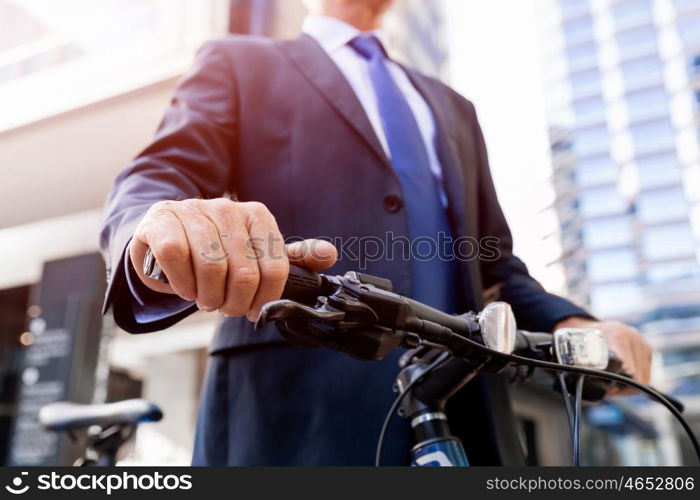 Successful businessman riding bicycle. Successful businessman in suit riding bicycle