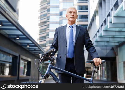 Successful businessman riding bicycle. Successful businessman in suit riding bicycle