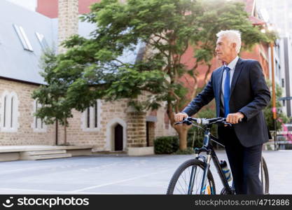 Successful businessman riding bicycle. Successful businessman in suit riding bicycle