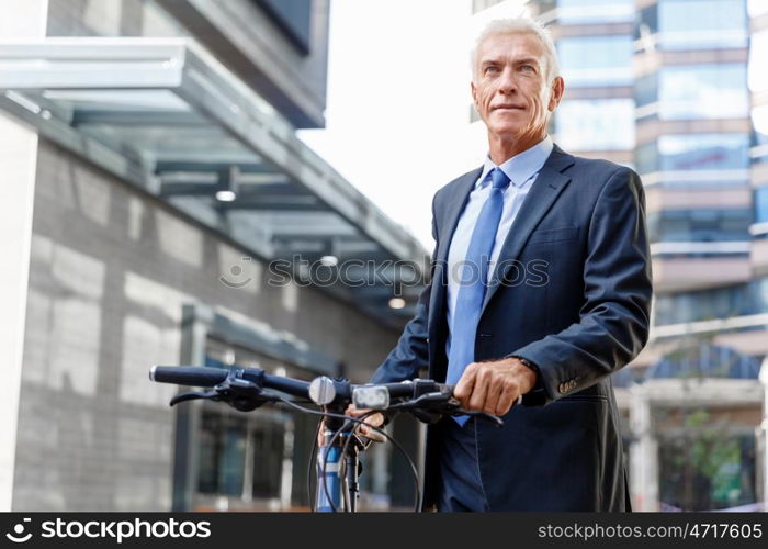 Successful businessman riding bicycle. Successful businessman in suit riding bicycle