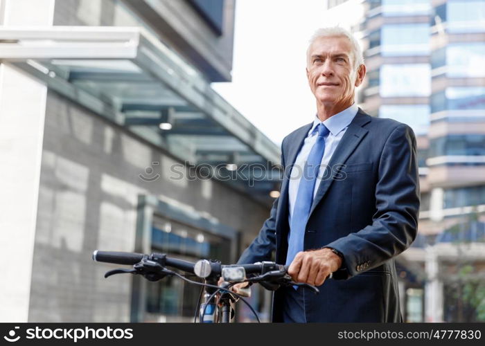 Successful businessman riding bicycle. Successful businessman in suit riding bicycle