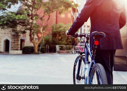 Successful businessman riding bicycle. Successful businessman in suit riding bicycle