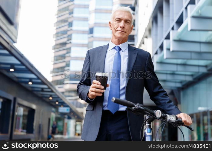 Successful businessman riding bicycle. Successful businessman in suit riding bicycle