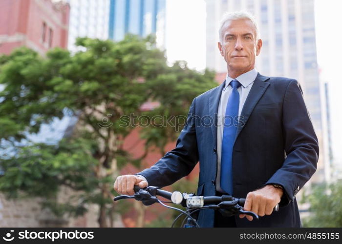 Successful businessman riding bicycle. Successful businessman in suit riding bicycle