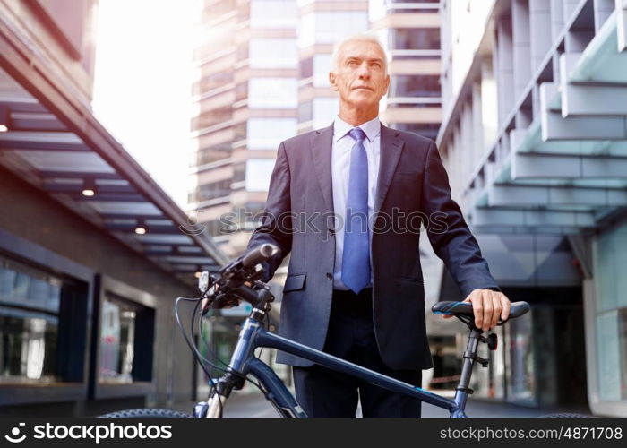 Successful businessman riding bicycle. Successful businessman in suit riding bicycle