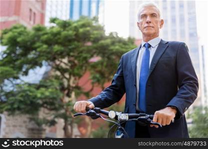 Successful businessman riding bicycle. Successful businessman in suit riding bicycle