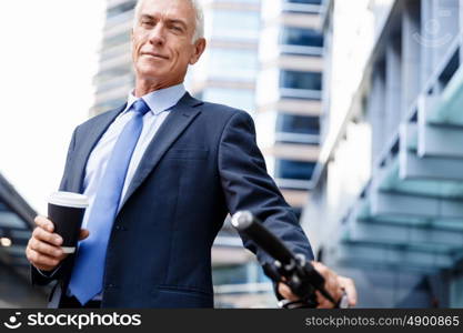 Successful businessman riding bicycle. Successful businessman in suit riding bicycle