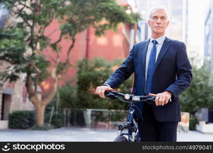 Successful businessman riding bicycle. Successful businessman in suit riding bicycle