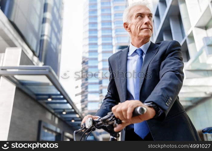 Successful businessman riding bicycle. Successful businessman in suit riding bicycle