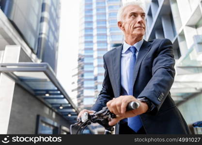 Successful businessman riding bicycle. Successful businessman in suit riding bicycle