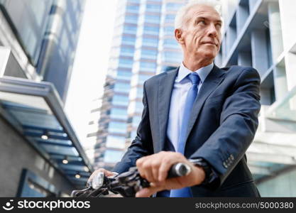 Successful businessman riding bicycle. Successful businessman in suit riding bicycle