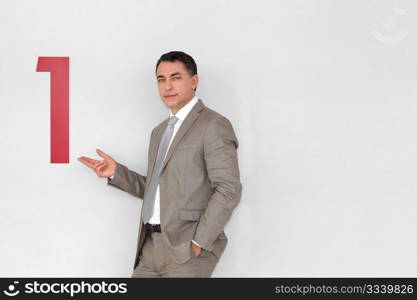 Successful businessman showing number one painted on wall