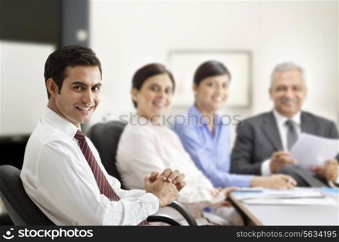 Successful businessman smiling with executives in a meeting