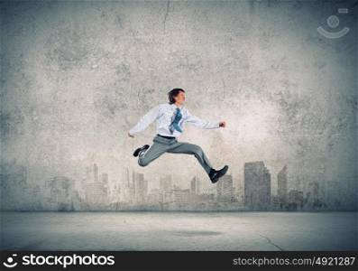 Successful businessman. Young businessman in jump against city background