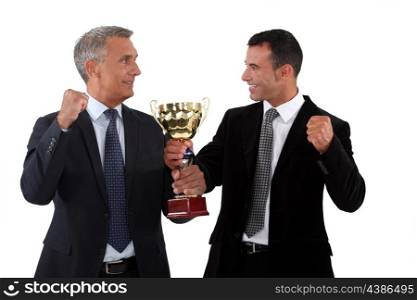 Successful businessmen holding a gold cup