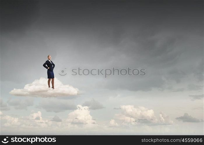 Successful businesswoman on cloud. Young confident businesswoman with hands on waist
