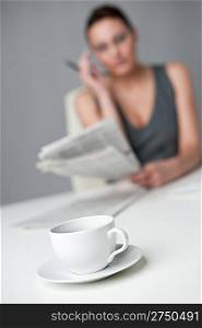 Successful businesswoman read newspaper at office, focus on morning coffee