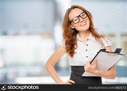 Successful businesswoman with folder posing in the office