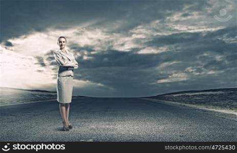 Successful businesswoman. Young confident businesswoman standing on asphalt road
