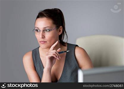 Successful executive businesswoman thinking at office, holding pen