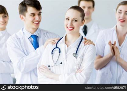 Successful female doctor. Attractive female doctor in uniform congratulated by colleagues