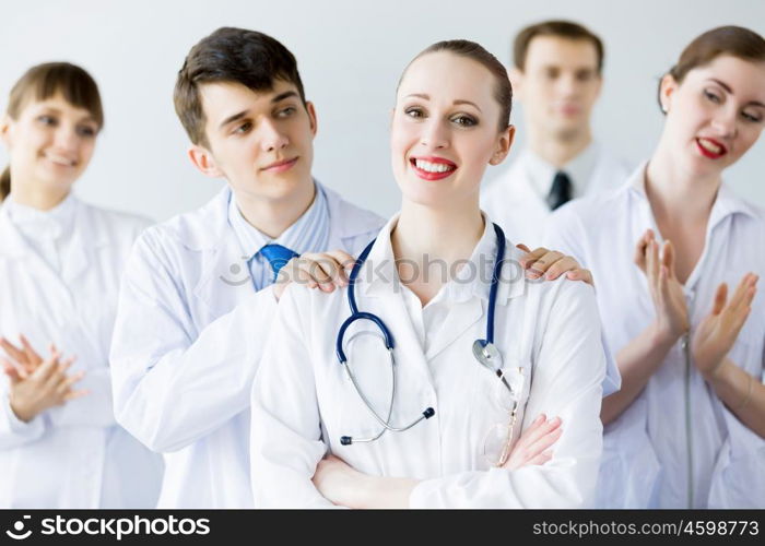 Successful female doctor. Attractive female doctor in uniform congratulated by colleagues