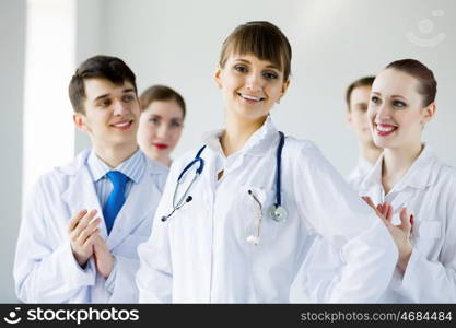 Successful female doctor. Attractive female doctor in uniform congratulated by colleagues