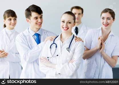 Successful female doctor. Attractive female doctor in uniform congratulated by colleagues