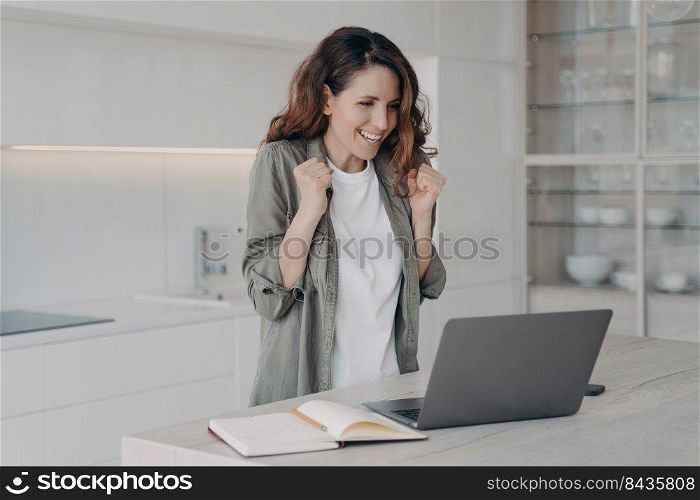 Successful female freelancer wins. Young caucasian woman says yes. Overjoyed lady has corporate internet session on laptop. Girl staying home on quarantine. Remote work and communication.. Successful female freelancer wins. Young caucasian woman says yes. Internet session on laptop.