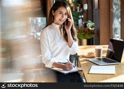 Successful female young adult asian freelancer working in cafe with laptop.