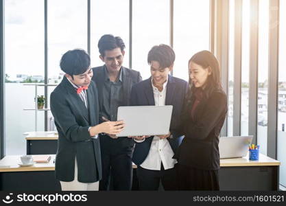 Successful happy workers Group of asian business people with diverse genders (LGBT) see a successful business plan on the laptop computer in the meeting room at office